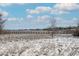 Scenic view of a wooden bridge crossing a field in winter, with a backdrop of trees and a cloudy blue sky at 1712 S Kline Way, Lakewood, CO 80232