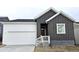 Charming home featuring a two-car garage, wooden siding, and inviting entryway at 17105 W 92Nd Loop, Arvada, CO 80007