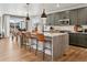 Open kitchen with dark green cabinets, an island with seating, and stainless steel appliances at 17105 W 92Nd Loop, Arvada, CO 80007