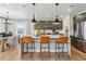 Modern kitchen featuring a large island with bar stools, stylish pendant lights, and stainless steel appliances at 17105 W 92Nd Loop, Arvada, CO 80007