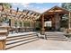 Entertainers deck with built in stone fireplace and dining and lounge areas at 6128 Songbird Cir, Boulder, CO 80303