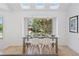 Bright dining room featuring a glass table, skylights, and a large window with views of the outdoor scenery at 6128 Songbird Cir, Boulder, CO 80303