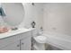 This bathroom features a round mirror, white vanity and a shower over tub at 5112 Duluth Ct, Denver, CO 80239