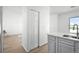 Well-lit view of a kitchen island with a sink, plus a pantry space and view to living room at 5112 Duluth Ct, Denver, CO 80239