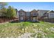 Backyard view of a two-story home with a deck and walkout basement at 12201 Village Cir, Brighton, CO 80603