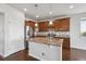 Beautiful kitchen features wood floors, stainless appliances, granite counters, and a center island at 12201 Village Cir, Brighton, CO 80603