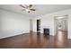Spacious living room features dark hardwood floors, a ceiling fan, and an elegant fireplace at 12201 Village Cir, Brighton, CO 80603