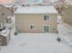 Rear view of the house covered in snow, showing a shed and backyard at 21621 Stoll Pl, Denver, CO 80249