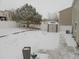 Snowy backyard with shed and mature tree at 21621 Stoll Pl, Denver, CO 80249