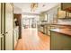 Open kitchen with light green cabinets and stainless steel appliances at 21621 Stoll Pl, Denver, CO 80249