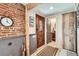 Stylish entryway featuring a brick accent wall, decorative wood trim, and a view into the bathroom at 2314 Dexter St, Denver, CO 80207