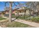 Charming home with a landscaped front yard enclosed by a black iron fence and mature trees at 2314 Dexter St, Denver, CO 80207