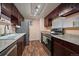 Well-lit kitchen with stainless steel appliances, granite countertops, and dark wood cabinets at 13393 E Asbury Dr # 103, Aurora, CO 80014