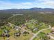 Wide aerial shot of a community nestled in rolling hills with lush green trees at 8427 S Custer Ln, Evergreen, CO 80439