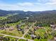 Picturesque aerial view of homes surrounded by forests and valleys under a blue sky at 8427 S Custer Ln, Evergreen, CO 80439