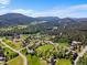 Expansive aerial view showing homes amidst rolling hills and lush forestry at 8427 S Custer Ln, Evergreen, CO 80439