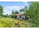 Spacious backyard with a deck, fire pit, mature trees, and lush greenery at 8427 S Custer Ln, Evergreen, CO 80439