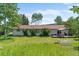 Beautiful backyard featuring a lush lawn, mature trees, deck and outdoor dining area at 8427 S Custer Ln, Evergreen, CO 80439