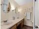 Bathroom with double vanity, framed mirrors and tiled shower at 8427 S Custer Ln, Evergreen, CO 80439