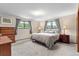 Spacious bedroom with neutral carpet, dresser, side tables and outside view at 8427 S Custer Ln, Evergreen, CO 80439