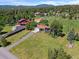 Aerial view of a home with a red roof, complemented by a lush lawn and mature trees at 8427 S Custer Ln, Evergreen, CO 80439