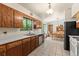 Open kitchen showcasing wood cabinetry, tile floors, and a view to the dining room at 8427 S Custer Ln, Evergreen, CO 80439