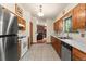Functional kitchen with tile floors, oak cabinets, stainless dishwasher, and a glimpse of the living room at 8427 S Custer Ln, Evergreen, CO 80439