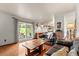 Cozy living room featuring hardwood floors, a sliding glass door, and comfortable leather seating at 8427 S Custer Ln, Evergreen, CO 80439