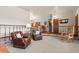Inviting living room with leather armchairs, wood railing and trim, and neutral carpet flooring at 8427 S Custer Ln, Evergreen, CO 80439