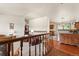 Open-concept living space with wood floors, wood railing, and access to the kitchen at 8427 S Custer Ln, Evergreen, CO 80439