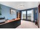 Bright home office featuring blue walls, large window with mountain views, and functional desk space at 8427 S Custer Ln, Evergreen, CO 80439