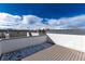 Expansive rooftop deck boasting wood-look flooring and panoramic views under a vibrant blue sky at 4551 Tennyson St, Denver, CO 80212