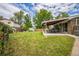 Lush backyard featuring a well-manicured lawn, covered patio, playhouse, shed, and mature trees at 8935 W Swarthmore Dr, Littleton, CO 80123