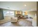 Inviting basement with a brick fireplace, plush carpeting, and large windows for natural light at 8935 W Swarthmore Dr, Littleton, CO 80123