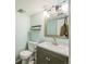 This half bathroom has a light blue wall color, mirror, and a floating shelf with toilet and sink at 8935 W Swarthmore Dr, Littleton, CO 80123