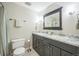 Bathroom featuring double sinks with granite countertops, dark wood cabinets, and modern fixtures at 8935 W Swarthmore Dr, Littleton, CO 80123
