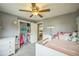 Charming bedroom with a ceiling fan, gray walls, white trim, and a closet filled with dress up clothes at 8935 W Swarthmore Dr, Littleton, CO 80123