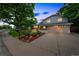 Beautifully landscaped home featuring a lush front yard and inviting curb appeal at dusk at 8935 W Swarthmore Dr, Littleton, CO 80123