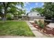 Charming two-story home featuring lush green lawn and landscaped front yard at 8935 W Swarthmore Dr, Littleton, CO 80123