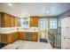 Well-lit kitchen featuring oak cabinets, neutral countertops, and a view to the backyard door at 8935 W Swarthmore Dr, Littleton, CO 80123