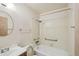 An older bathroom featuring a tub-shower combo with grab bars and a round mirror at 831 Sable Blvd, Aurora, CO 80011