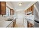 A kitchen featuring wood cabinets, white countertops, standard appliances, and a dining area at 831 Sable Blvd, Aurora, CO 80011