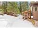 Backyard featuring a chicken coop in a snowy setting with surrounding trees and natural landscape at 5575 Jackpine Rd, Evergreen, CO 80439