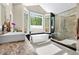 Modern bathroom featuring a soaker tub, walk-in shower, and a large picture window at 5575 Jackpine Rd, Evergreen, CO 80439