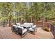 Spacious deck with outdoor furniture set amongst tall pine trees at 5575 Jackpine Rd, Evergreen, CO 80439