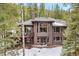 Inviting two-story home with multiple decks and a wooded backdrop at 5575 Jackpine Rd, Evergreen, CO 80439