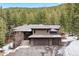 Attractive exterior featuring a three-car garage, grand entrance staircase, and well-maintained grounds in a serene setting at 5575 Jackpine Rd, Evergreen, CO 80439