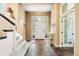 Inviting foyer with stone floors, staircase, natural light and access to another room with door with glass panes at 5575 Jackpine Rd, Evergreen, CO 80439
