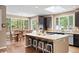 A spacious kitchen is showcased with a central island, granite countertops and a view of the outdoors at 5575 Jackpine Rd, Evergreen, CO 80439
