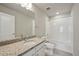 Bright bathroom featuring a granite countertop, white cabinets, and a tub with white tile surround at 7360 Watercress Dr, Littleton, CO 80125